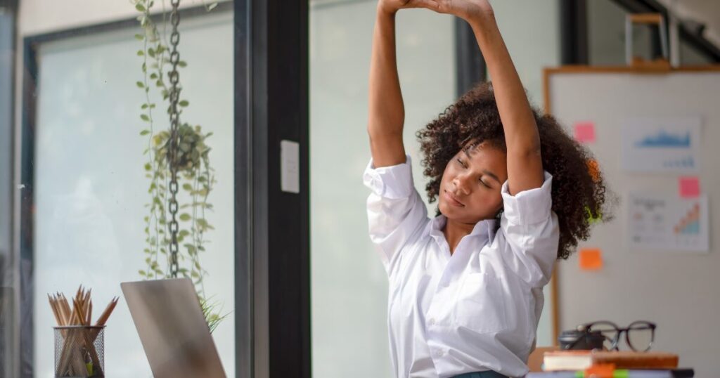 woman in a white shirt doing gentle stretches for her back and shoulders