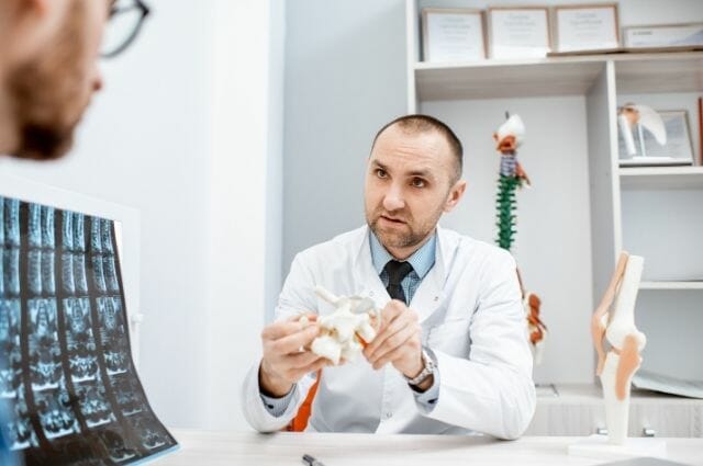 radiologist explaining the spinal condition of a patient