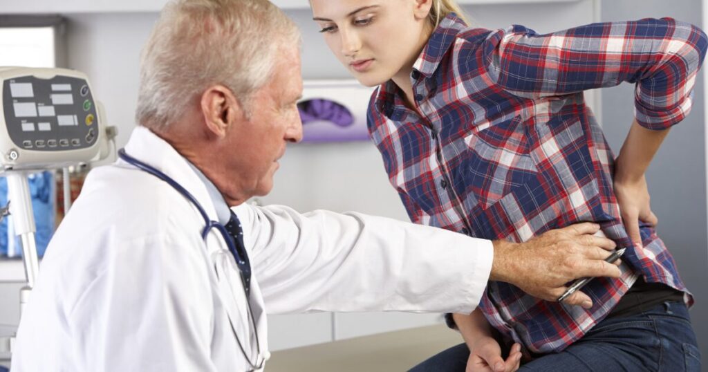 woman getting checked by a doctor for back pain