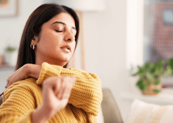 woman holding her shoulders due to pain