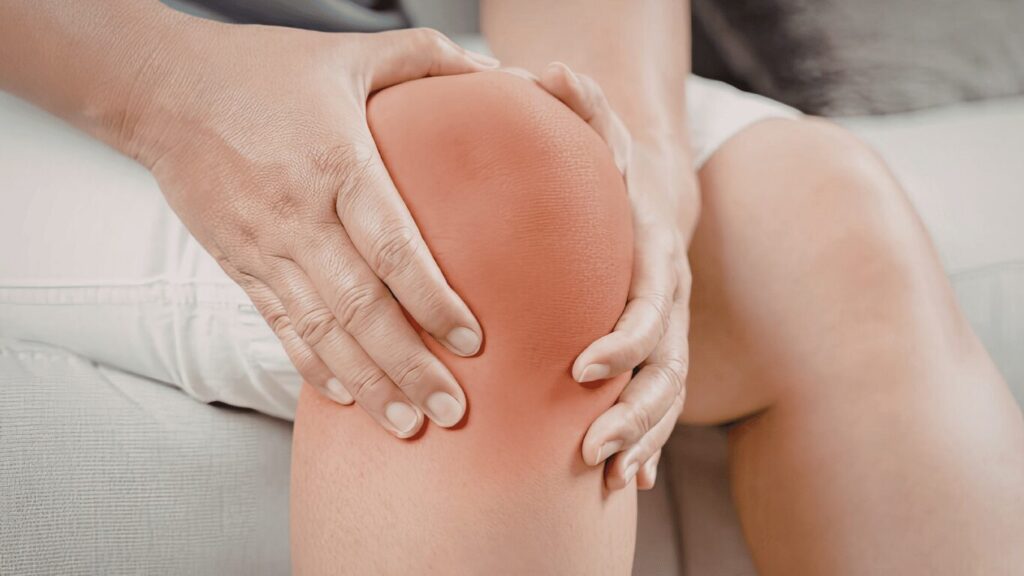 a person sitting holding his swollen knee