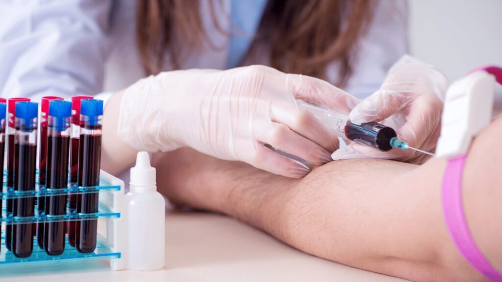A doctor collecting a blood sample from a seated patient